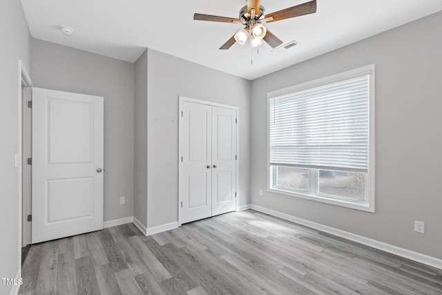 unfurnished bedroom with light wood-type flooring, a closet, visible vents, and baseboards