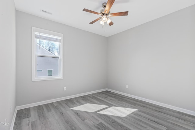 spare room with visible vents, ceiling fan, light wood-style flooring, and baseboards