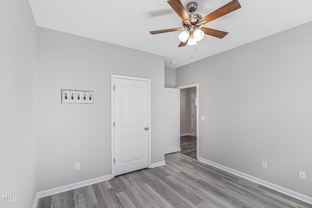 unfurnished bedroom featuring light wood-type flooring, ceiling fan, and baseboards