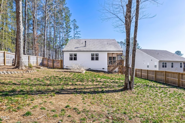 back of house featuring a yard, stairway, crawl space, and a fenced backyard