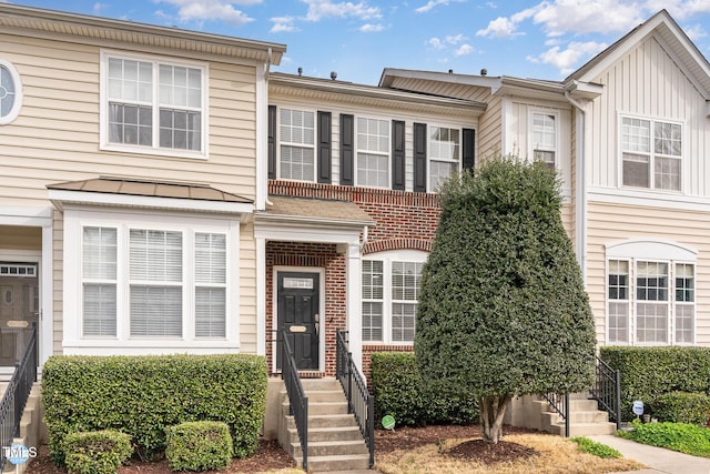 townhome / multi-family property with brick siding and a standing seam roof