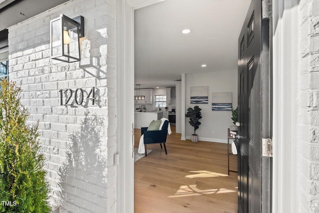 interior space featuring recessed lighting, baseboards, and light wood finished floors