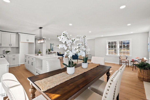 dining area featuring baseboards, light wood-type flooring, and recessed lighting