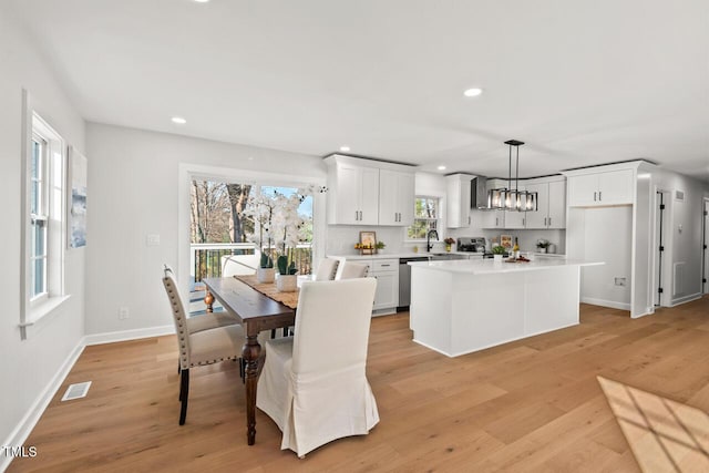 dining area with light wood-type flooring, visible vents, a notable chandelier, and recessed lighting