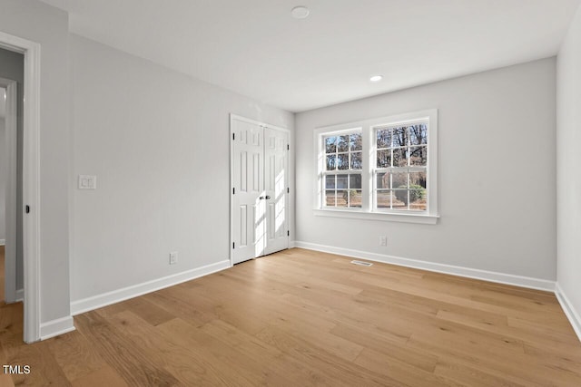 empty room featuring baseboards, recessed lighting, visible vents, and light wood-style floors