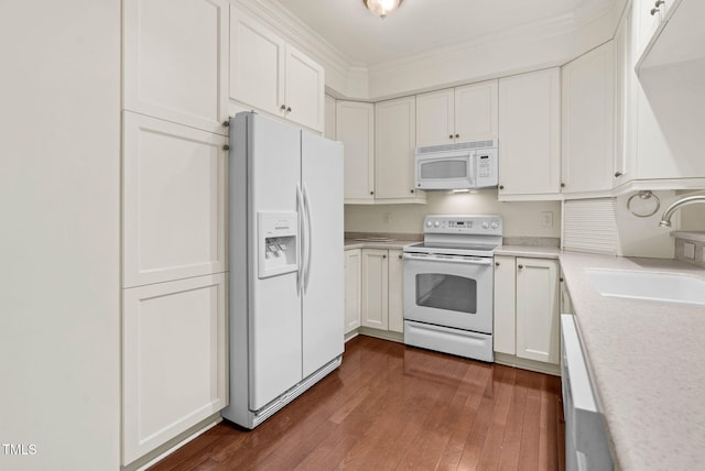 kitchen with light countertops, white appliances, a sink, and white cabinets