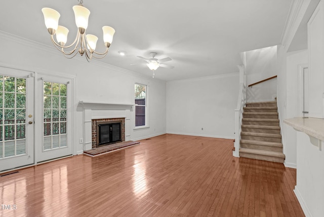 unfurnished living room with stairway, a fireplace, visible vents, and crown molding