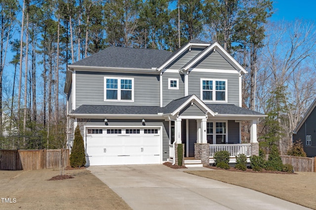 view of front of house with covered porch, fence, driveway, and an attached garage