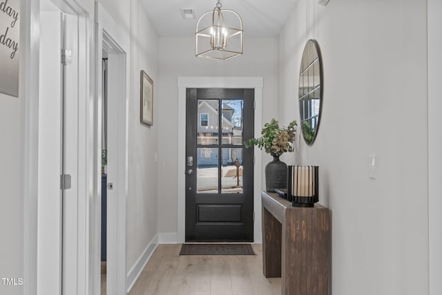 entrance foyer with a chandelier, baseboards, visible vents, and light wood finished floors