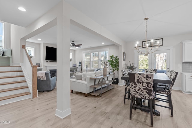 dining space with recessed lighting, plenty of natural light, a fireplace, and light wood-style floors