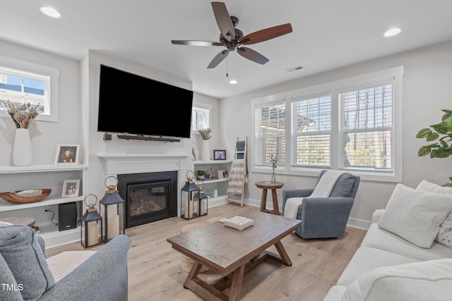 living area with light wood-type flooring, plenty of natural light, and visible vents