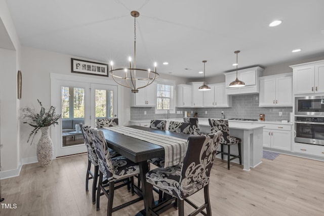 dining room with a notable chandelier, recessed lighting, baseboards, and light wood-style floors