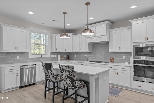 kitchen with stainless steel appliances, light countertops, and white cabinets