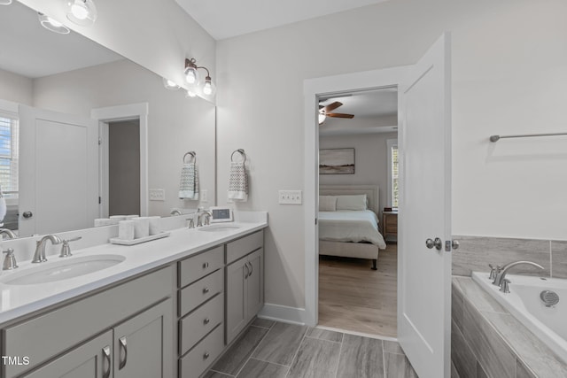 bathroom featuring a healthy amount of sunlight, ensuite bath, and a sink