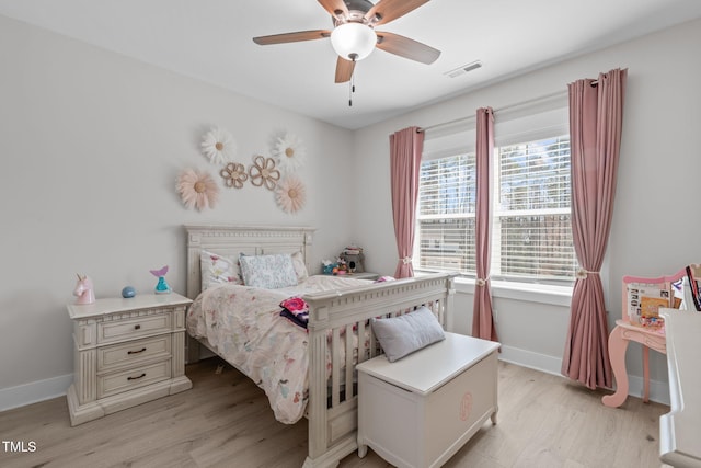 bedroom with light wood finished floors, baseboards, visible vents, and a ceiling fan