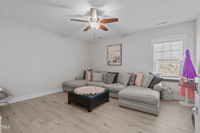 living area with light wood-style floors, baseboards, visible vents, and a ceiling fan