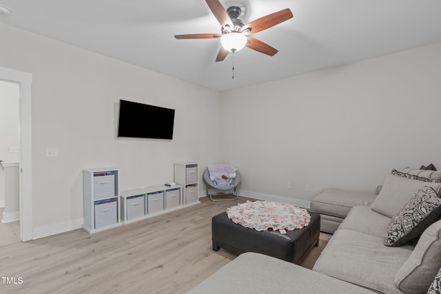 living area with light wood-style floors, ceiling fan, and baseboards