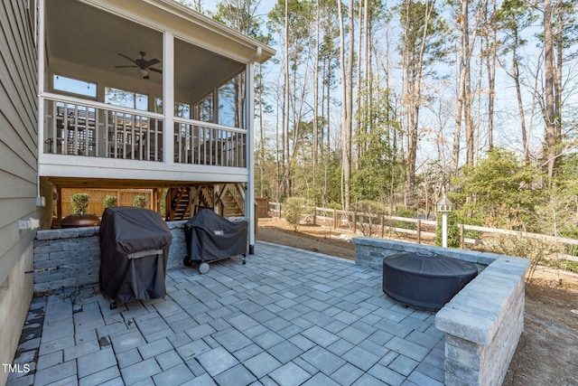 view of patio featuring ceiling fan, area for grilling, fence, and a sunroom