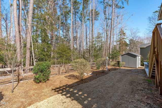 view of yard with an outbuilding, a fenced backyard, and a storage shed