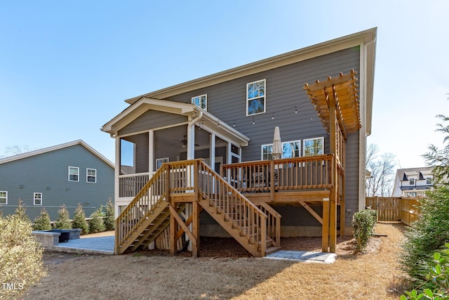 back of property with a sunroom, fence, a wooden deck, and stairs