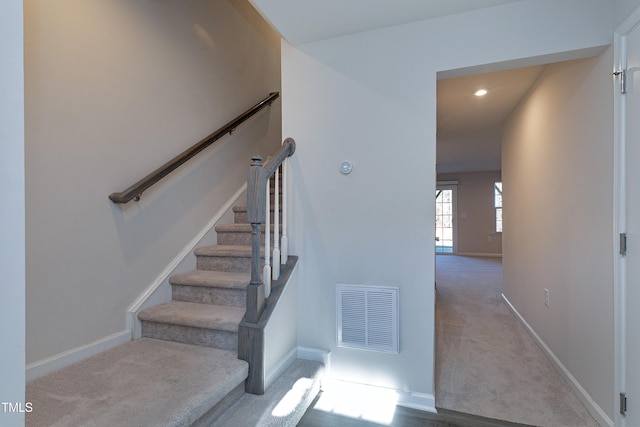 stairs with carpet floors, baseboards, visible vents, and recessed lighting