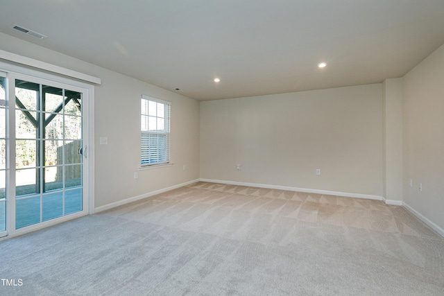 spare room featuring light colored carpet, visible vents, baseboards, and recessed lighting