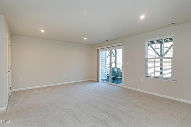 empty room with a healthy amount of sunlight, visible vents, and baseboards