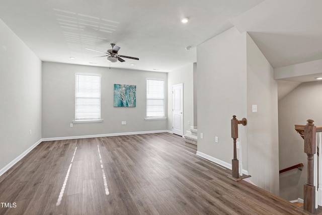 spare room with baseboards, dark wood finished floors, and a ceiling fan