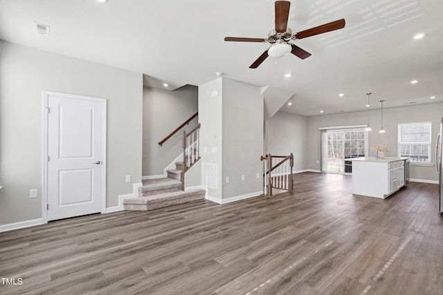 unfurnished living room with recessed lighting, visible vents, baseboards, and wood finished floors