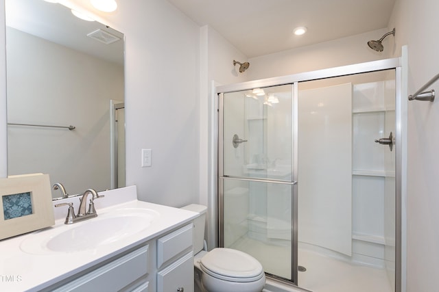 bathroom featuring visible vents, a shower stall, toilet, and vanity