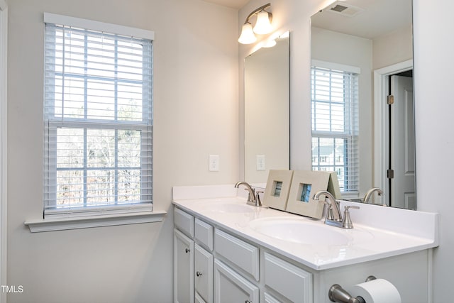 bathroom with plenty of natural light, visible vents, and a sink