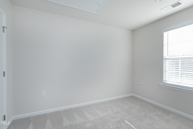 spare room with light carpet, visible vents, and baseboards