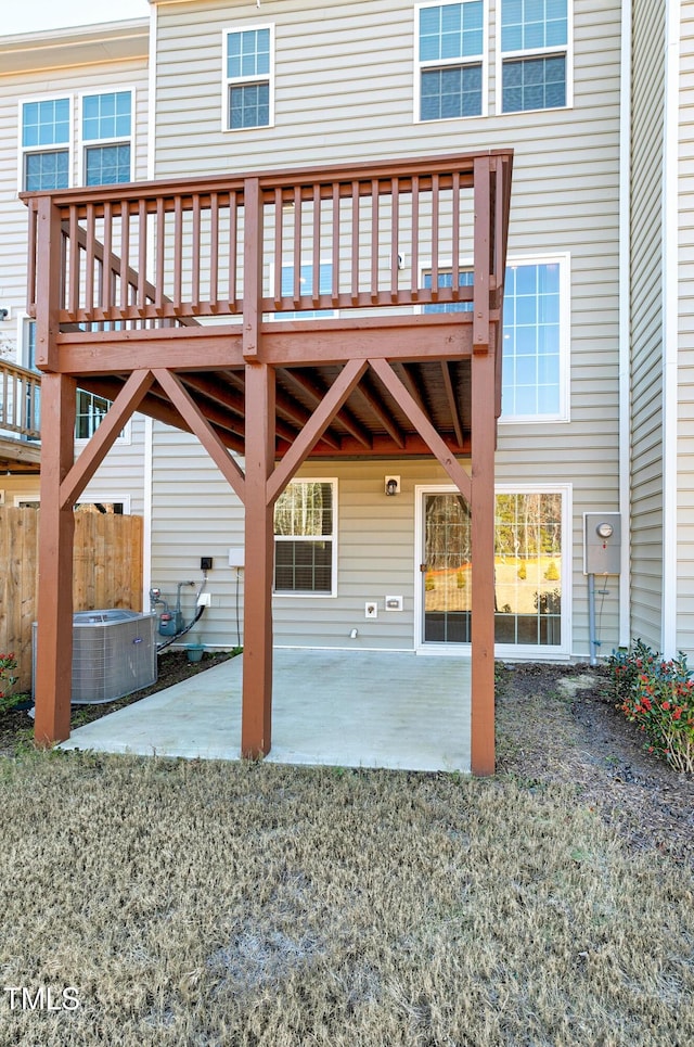 rear view of property with central AC unit, a patio area, fence, and a yard