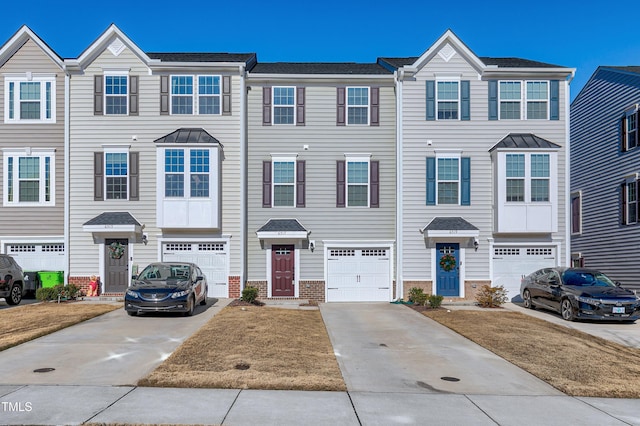 townhome / multi-family property with a garage, brick siding, and driveway