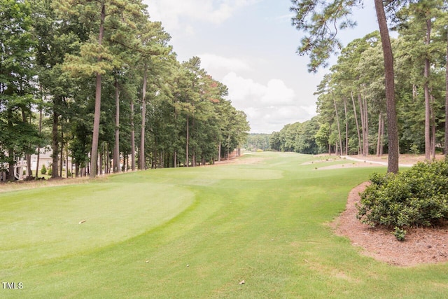 view of home's community featuring golf course view and a yard