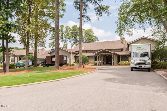 view of front of house featuring aphalt driveway and a front yard