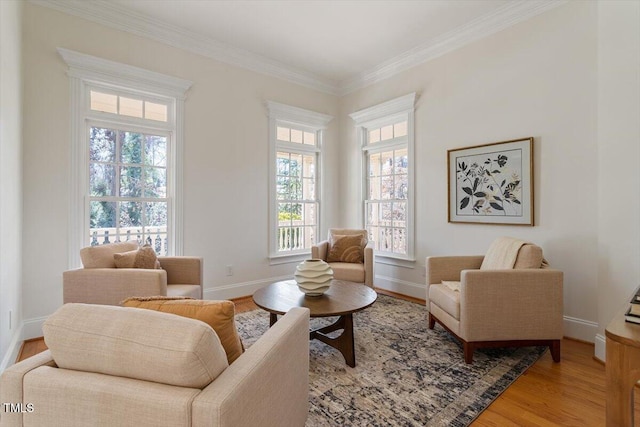 sitting room featuring light wood-type flooring, baseboards, and ornamental molding