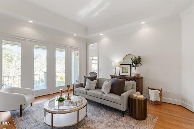 living room featuring ornamental molding, plenty of natural light, and light wood-style flooring