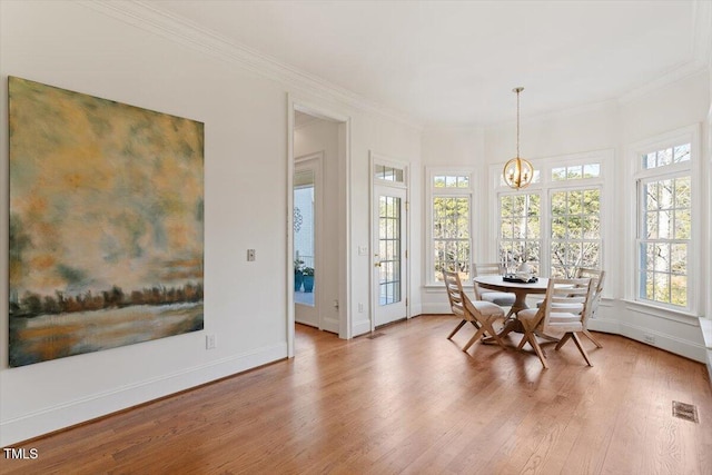 dining space with visible vents, crown molding, and wood finished floors