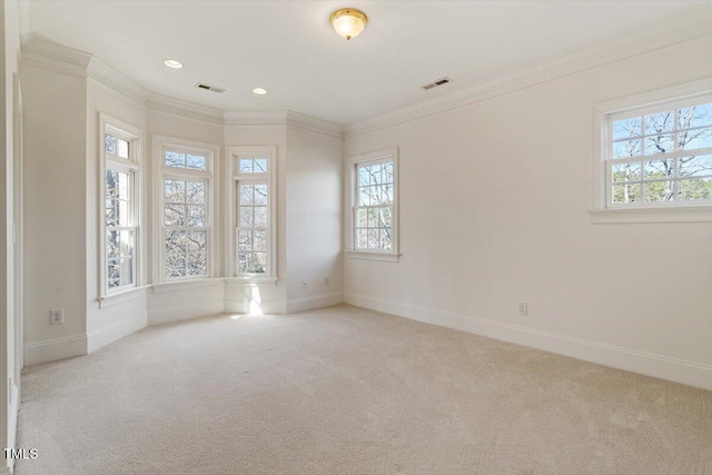 empty room featuring baseboards, light colored carpet, visible vents, and crown molding