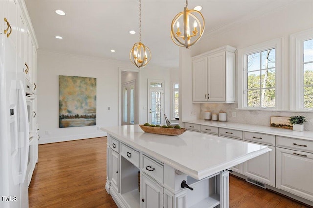 kitchen featuring a center island, decorative light fixtures, open shelves, light countertops, and white cabinetry