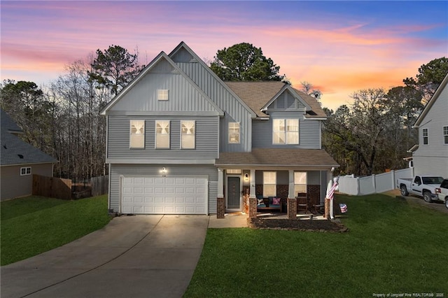 view of front facade featuring concrete driveway, board and batten siding, fence, and a lawn