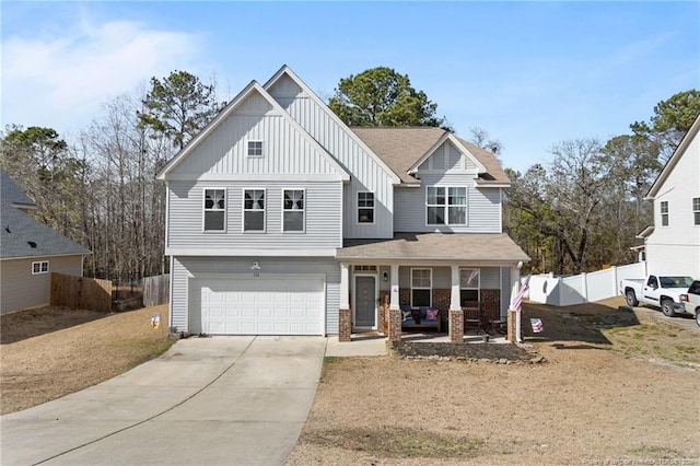 view of front of house featuring a porch, concrete driveway, an attached garage, board and batten siding, and fence