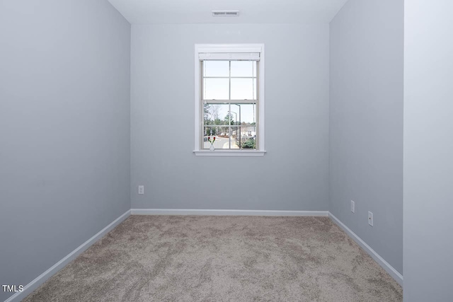 carpeted spare room featuring visible vents and baseboards