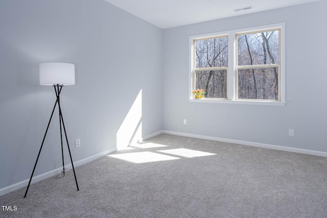 carpeted empty room featuring visible vents and baseboards