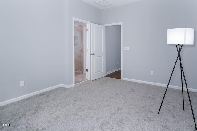 unfurnished bedroom with ensuite bathroom, visible vents, baseboards, and carpet floors