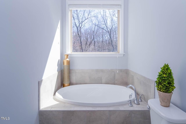 full bath featuring toilet and a bath