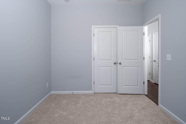 unfurnished bedroom with carpet flooring, visible vents, and baseboards