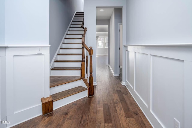 staircase featuring baseboards and wood finished floors