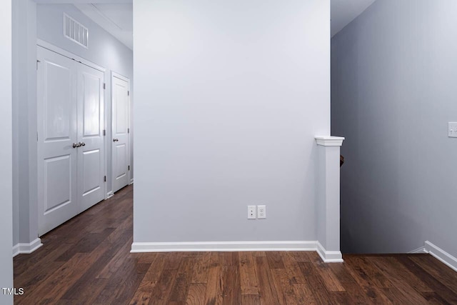 unfurnished room with dark wood finished floors, visible vents, and baseboards